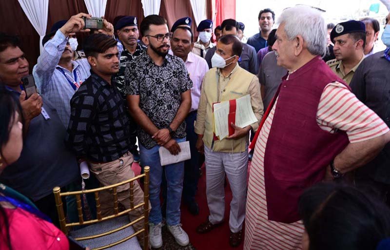 Lt Governor Manoj Sinha interacts with Shri Amarnathji pilgrims and volunteers at transit camp of Pantha Chowk in Srinagar on Sunday.